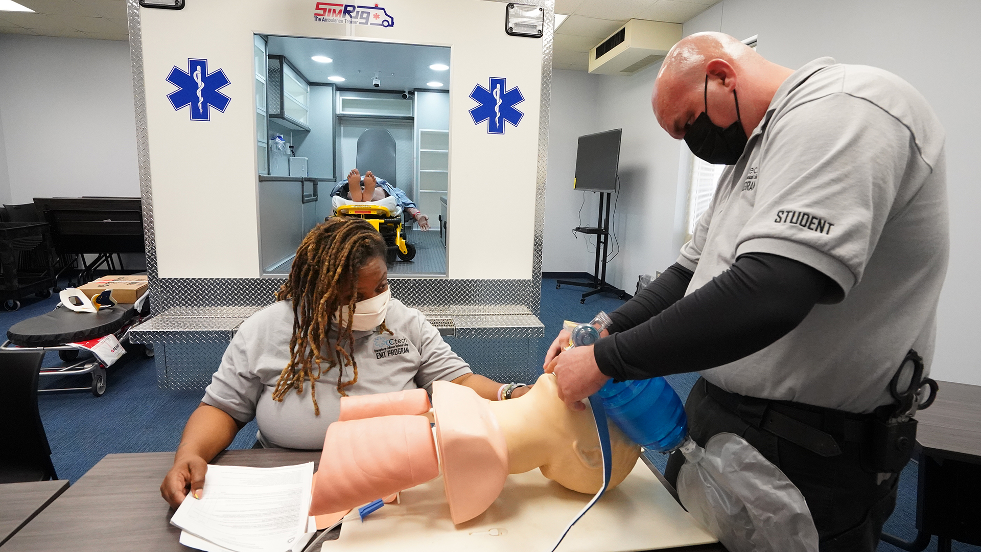 EMT students in lab with respiratory dummy