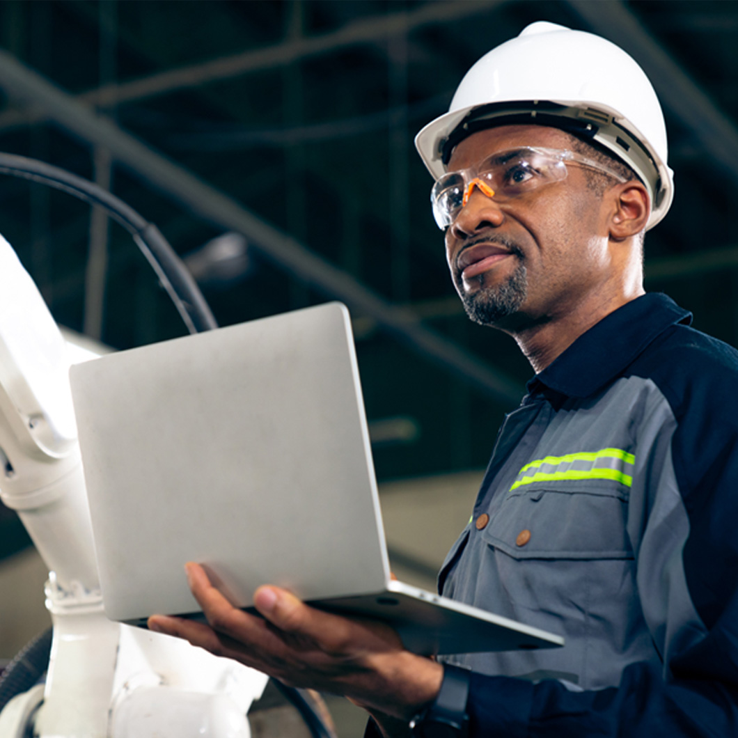 black male factory worker with laptop and hardhat