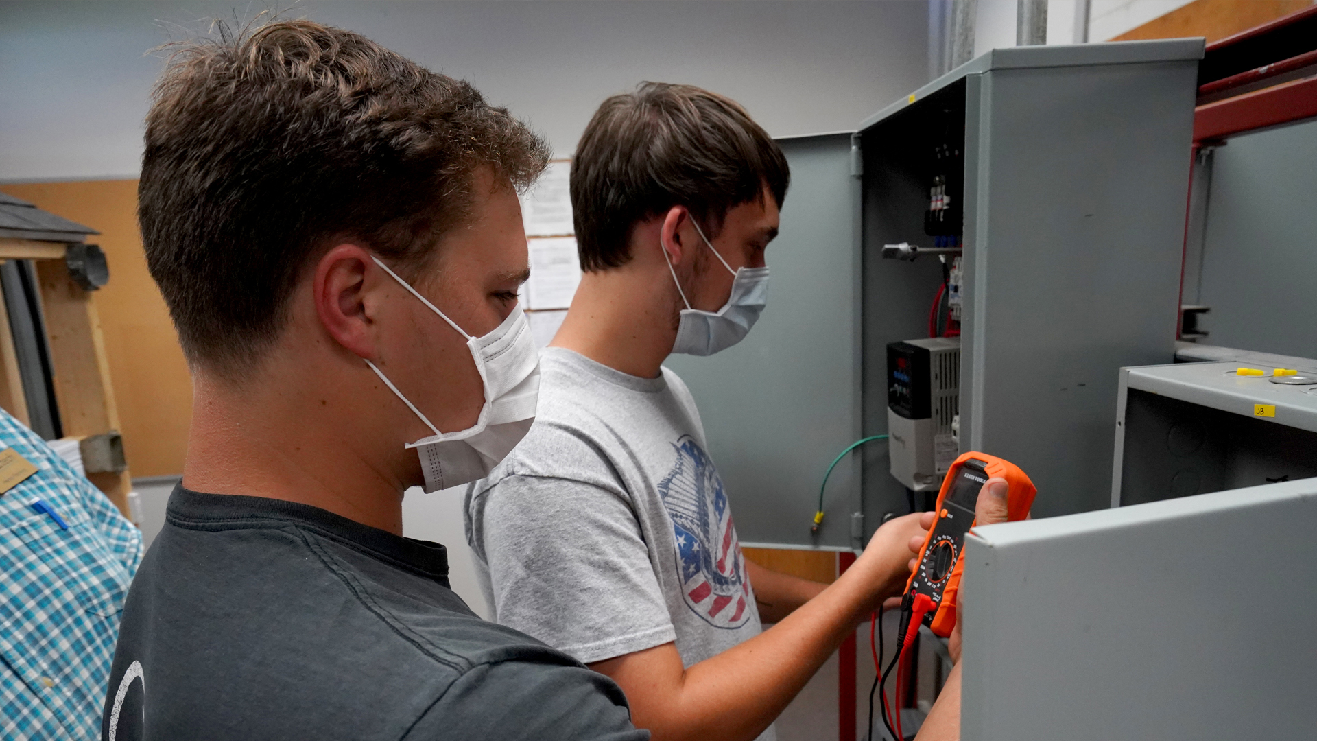 Two students at electrical panel